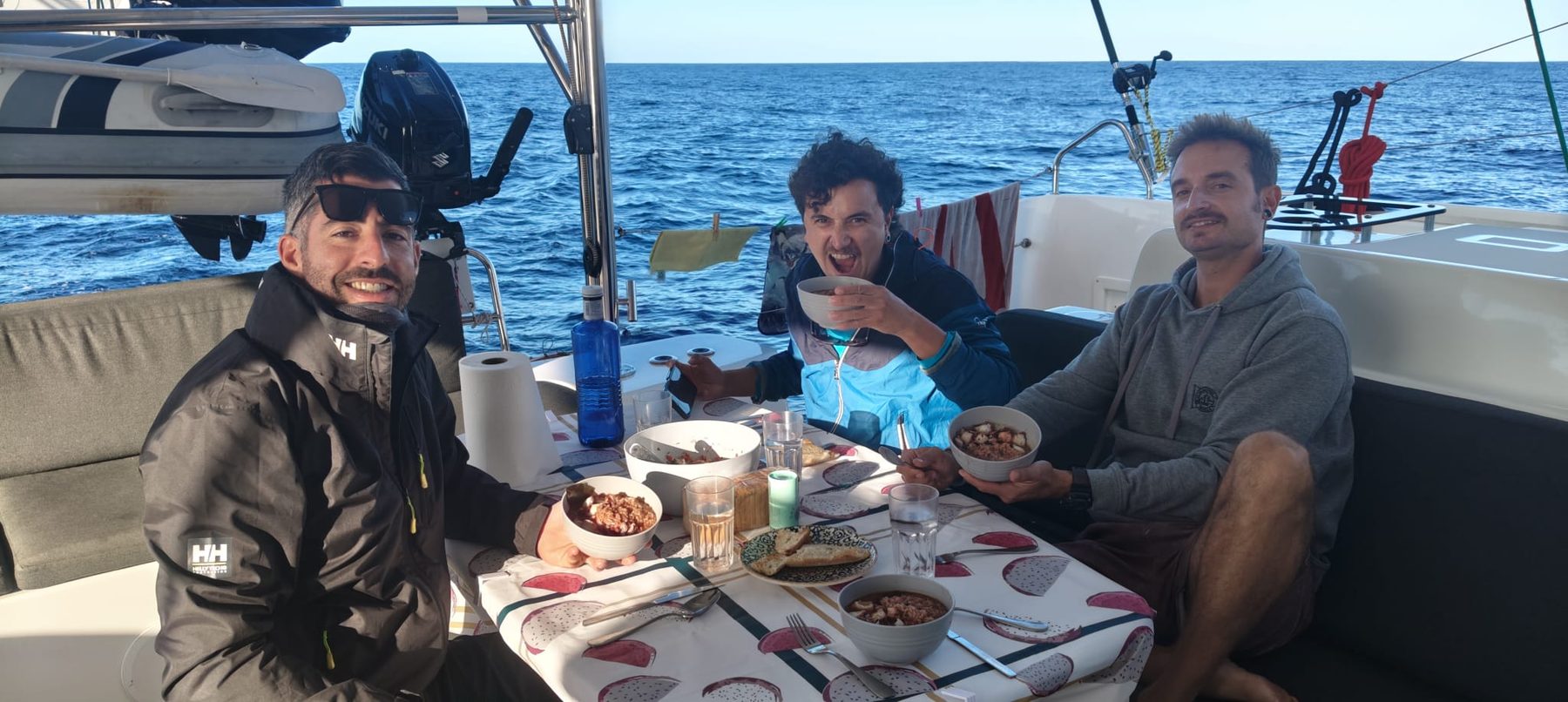 Part of the crew having a meal in the catamaran’s cockpit in mid-Atlantic